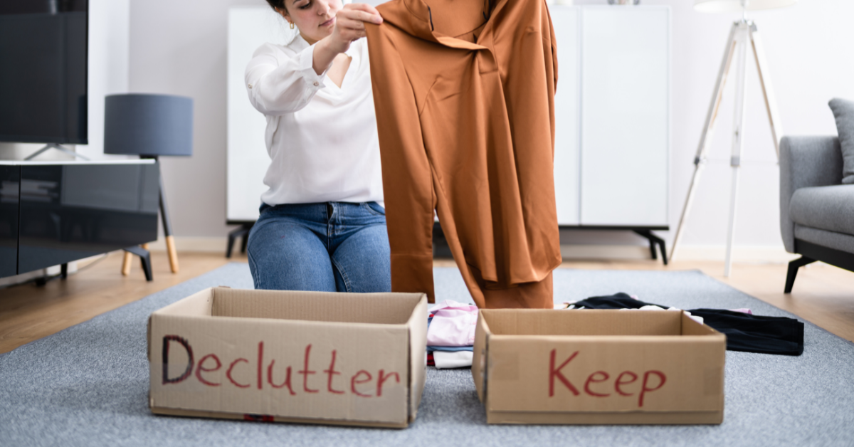 a person decluttering their home and sorting clothes into boxes