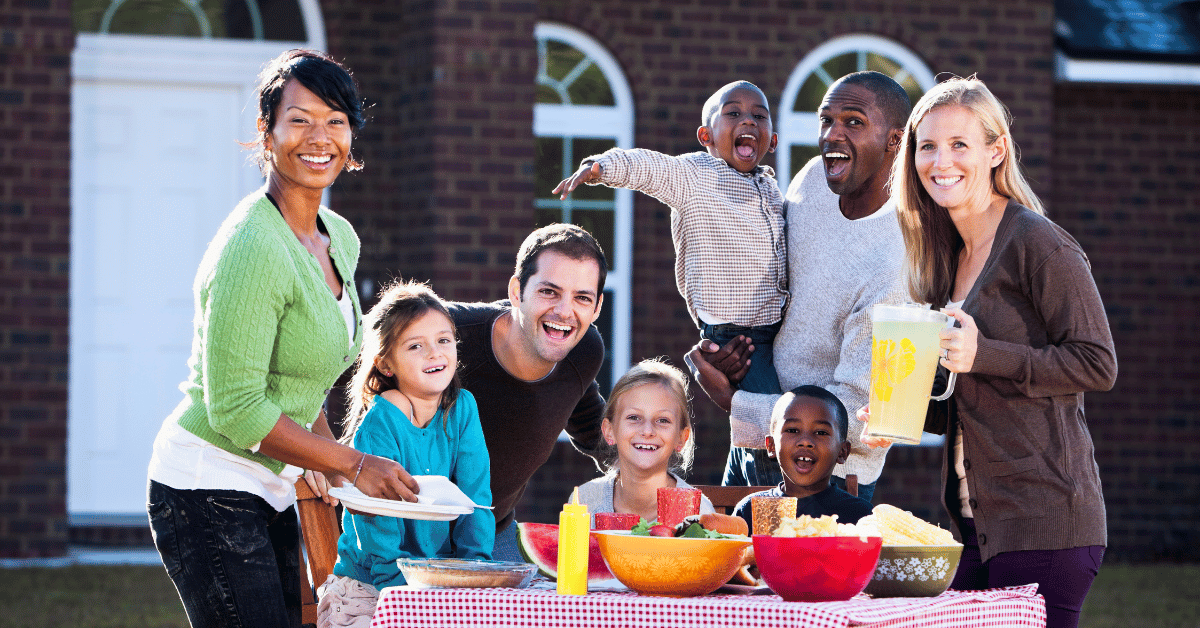 group of neighbors posing for a photo while enjoying food together
