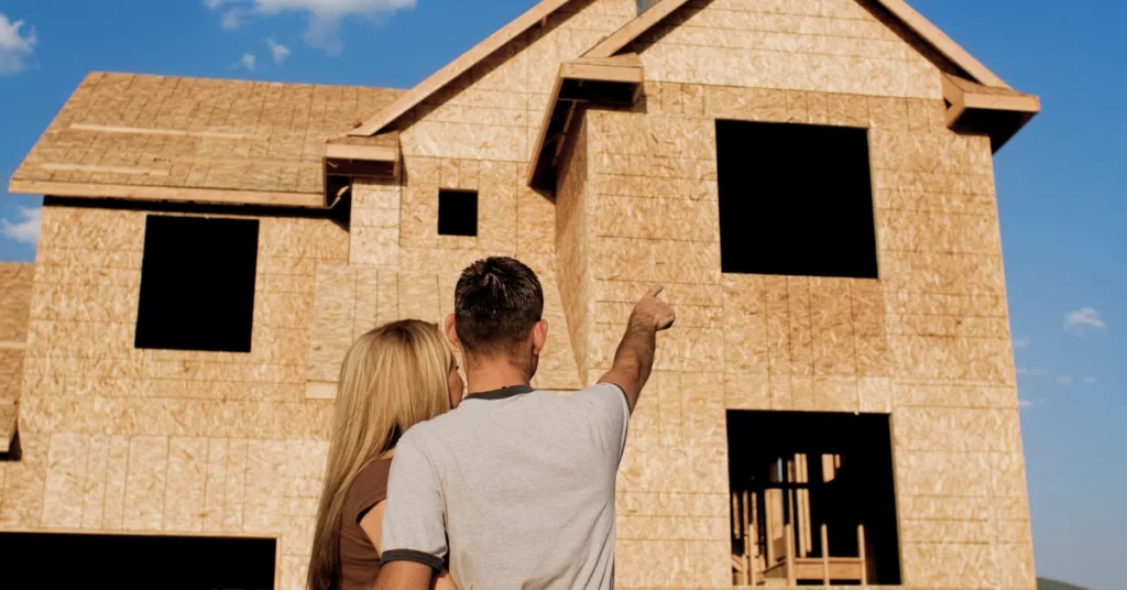 couple pointing at new construction home